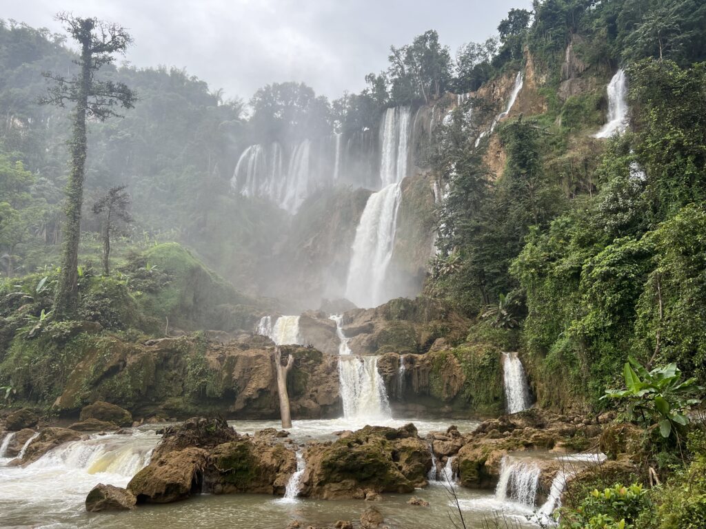 Thi Lo Su Waterfall: The vast, misty curtain of Thailand's largest waterfall plunging over multi-tiered limestone cliffs during the wet season.