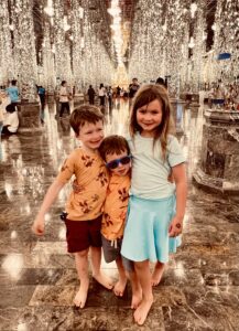 Three children stand among the crystal columns of Wat Chantharam