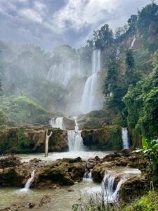 Thi Lo Su Waterfall: Wide view of Thailand's largest waterfall showing the misty, powerful tiers and muddy river basin during the wet season in Umphang.