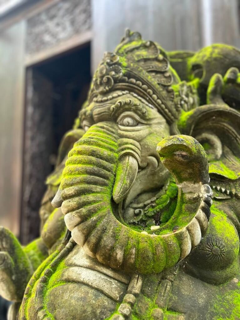 Moss-covered stone Ganesha sculpture at the Baan Dam Black House Museum