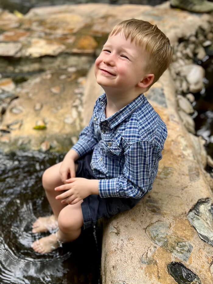 toddler resting feet jungle stream thailand