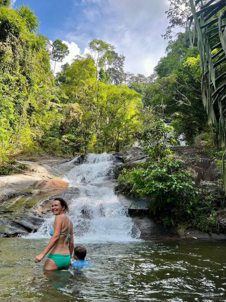 Family swimming in the cool water at the base of the multi-tiered Ton Pliw waterfall near Kachong Hills Tented Resort in Trang.