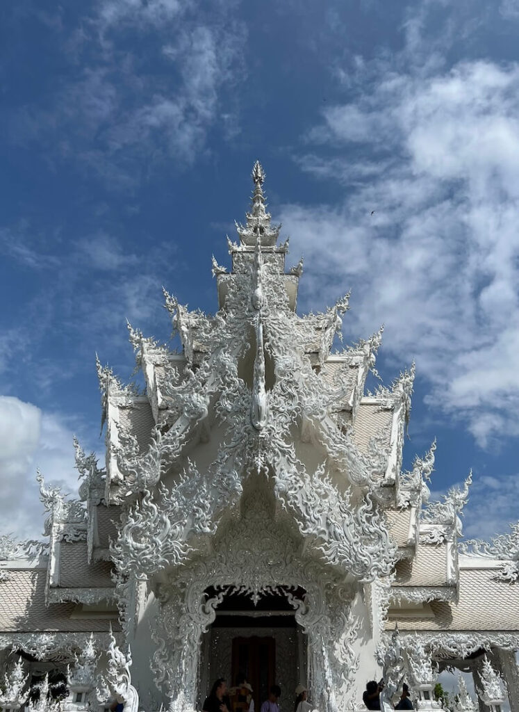 Close-up of the ornate spire and roof detail of the White Temple Wat Rong Khun