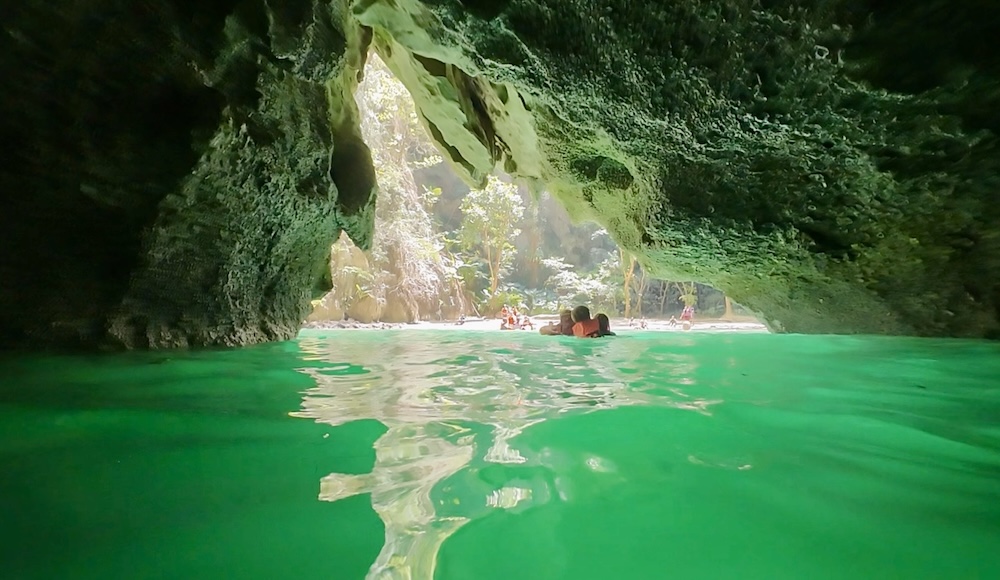 The Emerald Cave glows a vibrant green where it opens up to a secret lagoon.