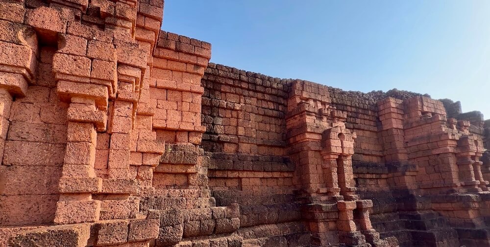 The pristine, sharply geometrically arranged reddish laterite stone blocks of the Khao Khlang Nok stupa foundation in Si Thep.